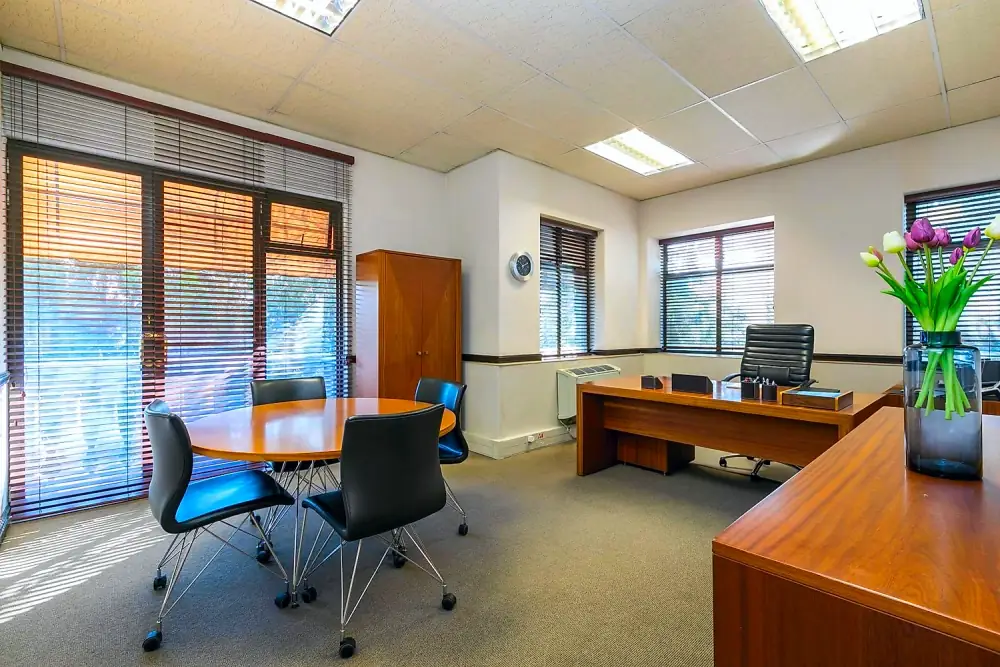 Executive suite with meeting table and private desk at The Workplace, Lonehill